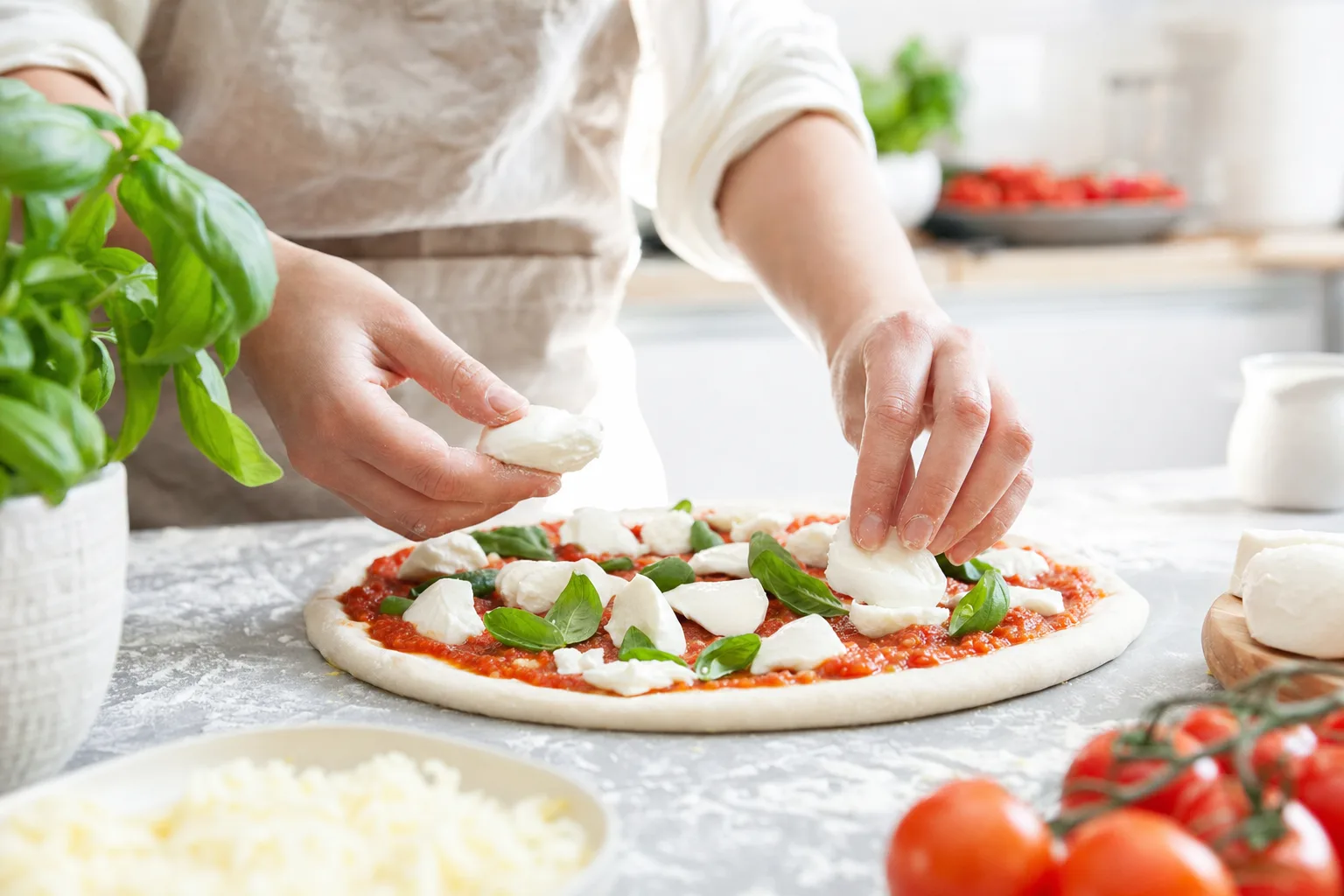 Frisch geriebener Käse wird auf eine Pizza gegeben